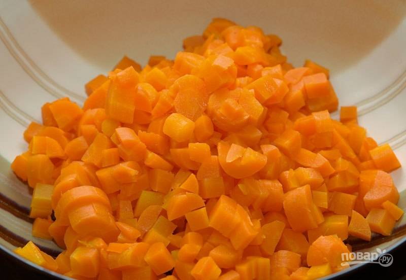 Морковь отварите до готовности. Почистите её, остудите и нарежьте кубиками.