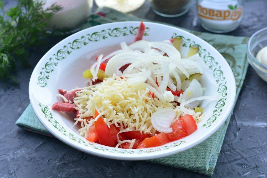 Добавьте в салат натертый сыр и маринованный лук.