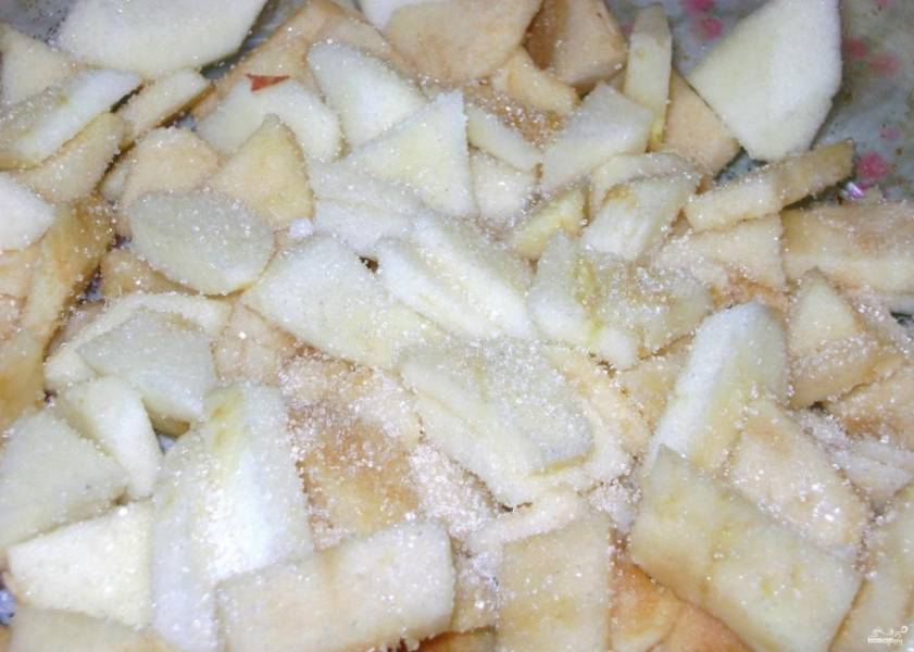 4.	Яблоки моем, срезаем кожуру и разрезаем на 4 части, вынимаем семечки и нарезаем их тонкими кусочками. Смазываем форму для выпекания подсолнечным маслом, выкладываем кусочки яблок и посыпаем их сахаром. По вкусу добавляем корицу.