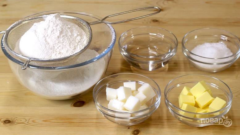 В большую миску просейте муку и добавьте соль. Добавьте масло и сало, порезанное кубиками. 