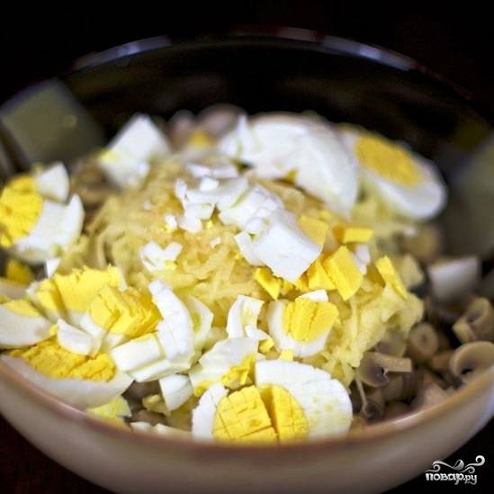 Яйца, сваренные вкрутую, нарезаем небольшими кубиками и тоже добавляем в салат.