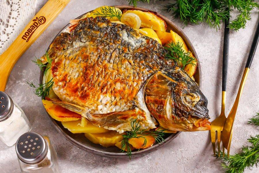 Выложите рыбу с картофелем на блюдо. Если потребуется, то разрежьте тушку или разломите. Подайте к столу горячей.