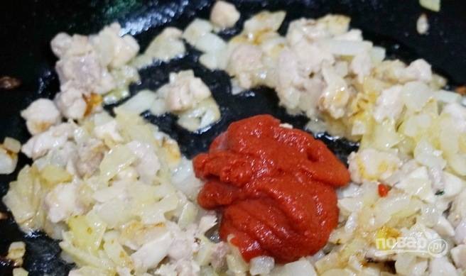 Потом в сковороду добавьте немного воды и томатную пасту. Перемешайте ингредиенты и продолжайте их готовить на медленном огне.