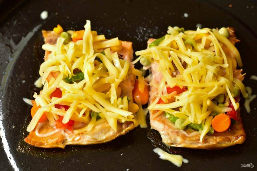 Отправьте рыбу в разогретую до 190 градусов духовку на 20 минут. После этого выложите на каждый кусок рыбы тертый сыр.