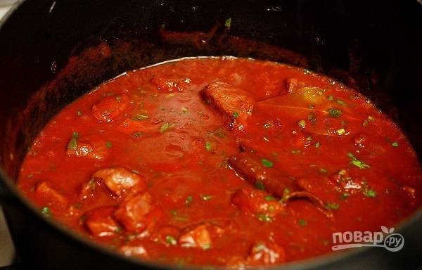 7. Выложите томатный соус и измельченную петрушку на сковороду. На среднем огне томите свинину до мягкости. 