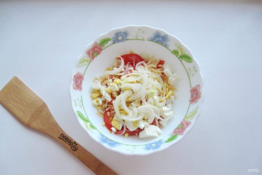 Репчатый лук очистите, помойте и нарежьте полукольцами. Залейте кипятком, дайте постоять 10 минут и воду слейте, а лук выложите в салат. Также добавьте измельченный зубчик чеснока.