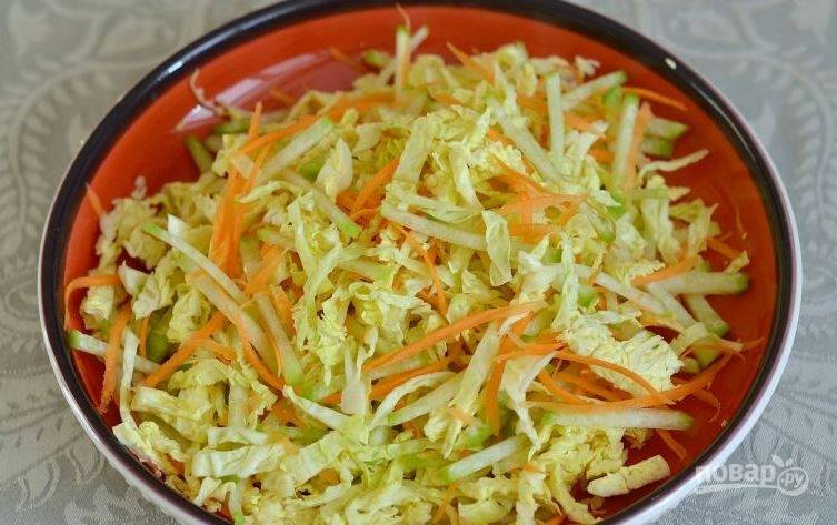 Возьмите большой салатник и выложите в него подготовленную капусту, редьку и морковь. Тщательно перемешайте овощи ложкой. 