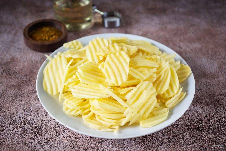 Нарежьте картофель тонкими ломтиками при помощи кухонного комбайна с насадкой для
нарезки или терки-мандалины. Если у вас таких устройств нет, используйте нож для чистки
овощей и "начистите" картошку тонкими пластинками.