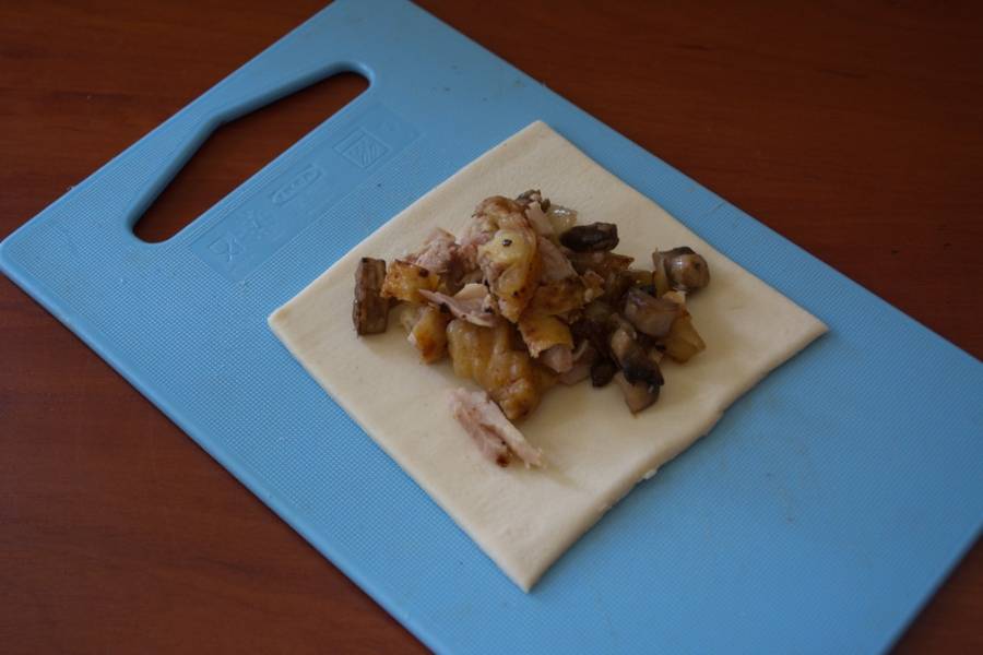 К начинке добавляем соль и перец. Перемешиваем.
Раскатайте слоеное тесто. Нарежьте на квадраты или прямоугольники. На каждый выложите начинку.