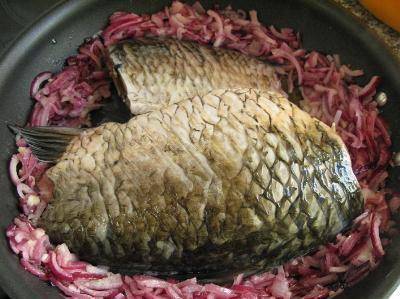 Моя сковорода со съемной ручкой, в ней я и буду запекать рыбу в духовке. Раздвигаем лук по бокам сковороды, выкладываем на освободившееся место рыбу. Если мало масла, можно его немного долить. Обжариваем рыбу.