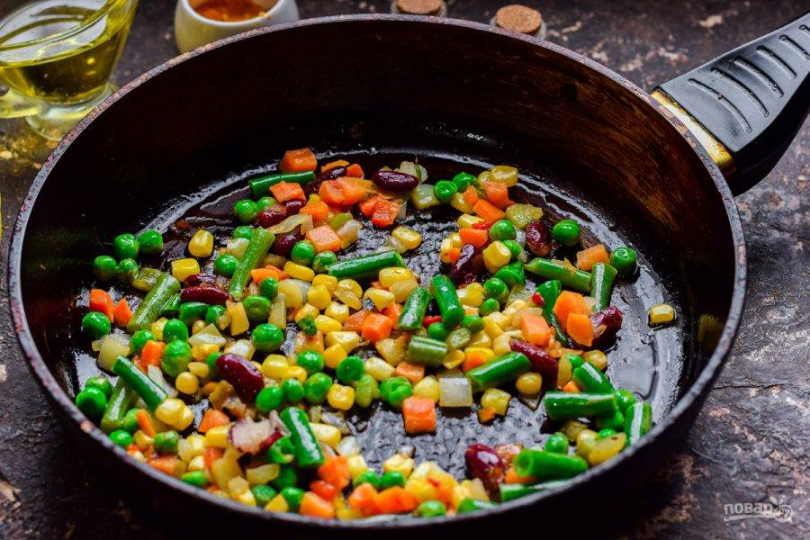 В сковороде прогрейте растительное масло, выложите подготовленные овощи. Жарьте овощи 7-8 минут.