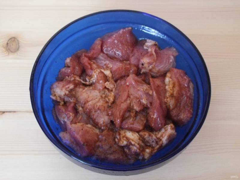 Переложите мясо в глубокую миску. Добавьте аждику, 1 ст. ложку растительного масла. Перемешайте.