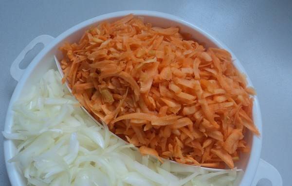 В чашу мультиварки залейте масло. Обжарьте лук в режиме "Жарка", до золотистого цвета, а затем добавьте морковь, натертую на крупной терке.