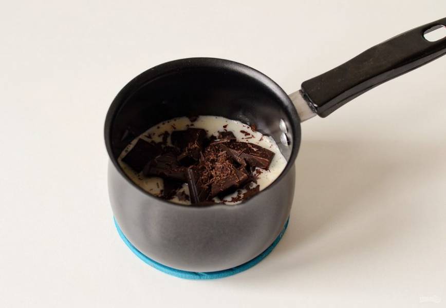 Коксовое молоко нагрейте, как только появится пар — снимете с плиты. Добавьте мелко порубленный шоколад, перемешайте, чтобы он растворился. Затем влейте растопленное масло какао. Еще раз перемешайте.
