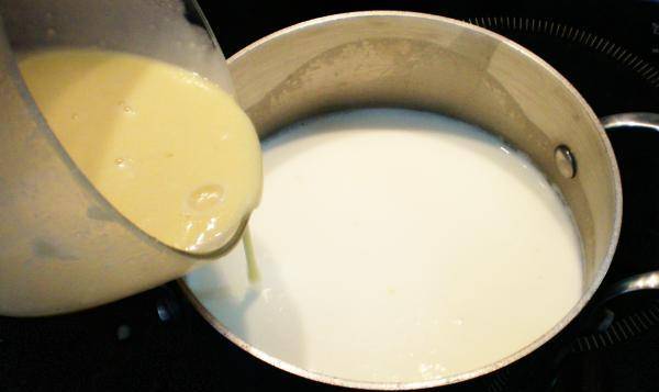 6. Молоко ставим на плиту.Пока оно греется, готовим смесь из сахара, яйца, муки и молока. Массу тщательно перемешиваем и тонкой струйкой вливаем в кипящее молоко. Крем готовим на маленьком огне, помешивая, пока не загустеет. 
