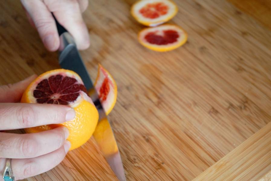 1. Апельсины нужно вымыть и немного обсушить. Острым ножом срежьте шкурку. В данном случае используются красные, так называемые сицилийские апельсины, однако можно взять и классические. 