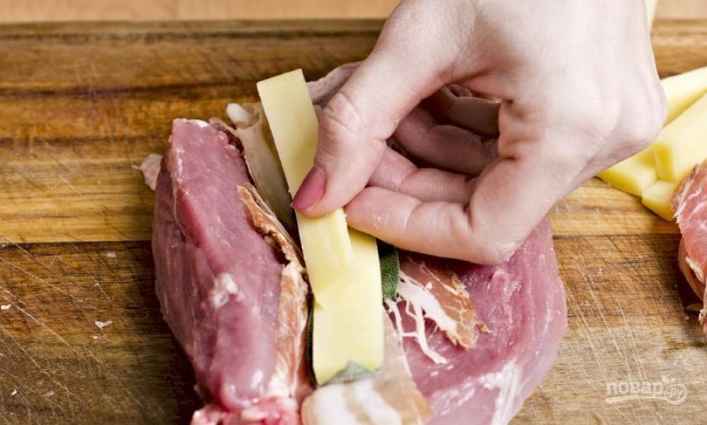 Твердый сыр нарежьте длинными брусочками. Затем выложите их в мясо. Лучше использовать такой сорт сыра, который хорошо плавится. 