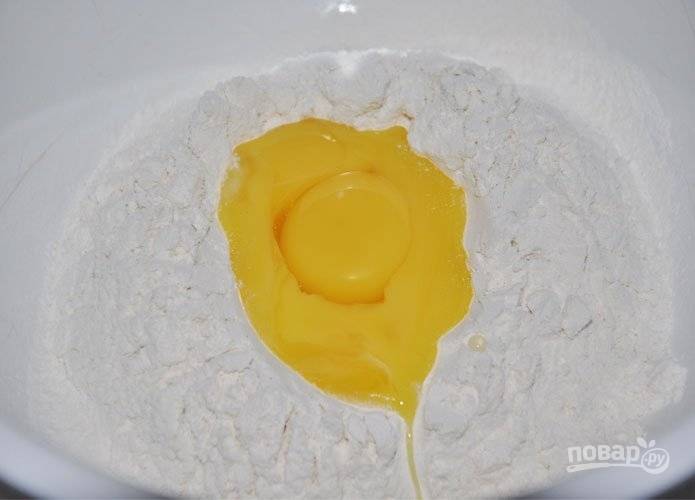 В большую миску просейте муку. В центре сделайте углубление. Влейте в него дрожжевую смесь, желтки отделённые от белков, и растопленное масло.