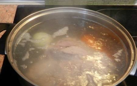 В кастрюле кипятим воду. Выкладываем в нее мясо, снова доводим до кипения, снимаем пену и добавляем лук и морковь. Варим до готовности свинины примерно 1 час.