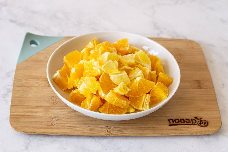 Апельсины и лимон тщательно помойте, затем очистите от кожуры. Удалите косточки, нарежьте дольками.