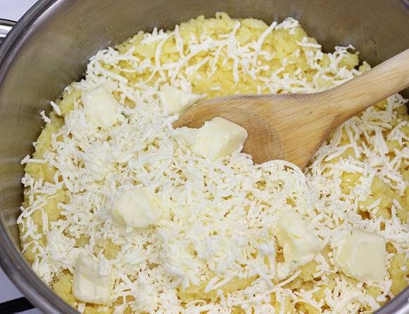 Сыр натираем на крупной терке. Добавляем в мамалыгу вместе со сливочным маслом. размешиваем до тех пор, пока масло и сыр не растают и не смешаются с кашей.