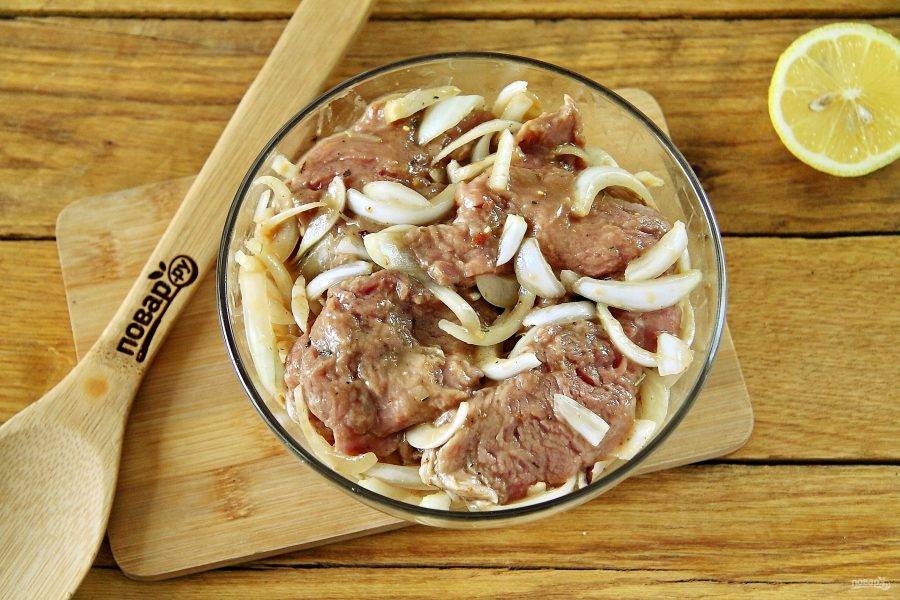 Сложите мясо в глубокую миску, добавьте нарезанный перьями лук и готовый маринад. Тщательно перемешайте, накройте миску крышкой и оставьте мясо мариноваться минимум на 2 часа. Можно на ночь.
