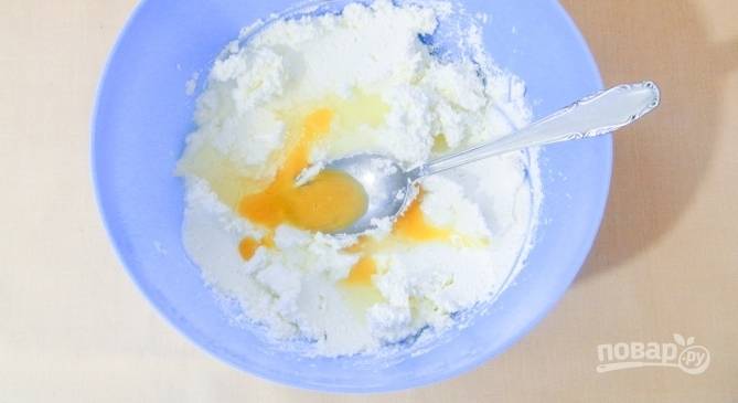 Достаньте из холодильника сливочное масло и положите его в миску. Дайте ему постоять при комнатной температуре, чтобы масло стало мягким. Добавьте к нему творог, соль, сахар, вбейте яйцо и тщательно перемешайте. 
