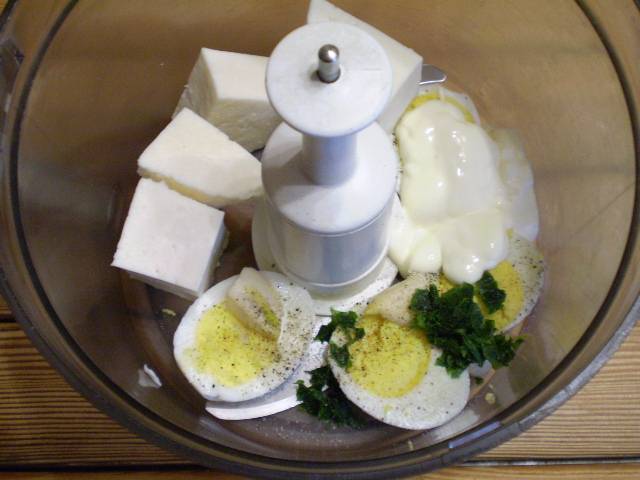 4. Сложим в чашу комбайна следующие продукты: сыр, яйца, чеснок, зелень, специи и майонез. Измельчаем.