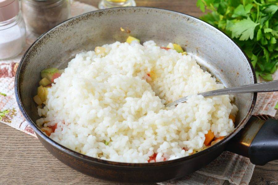 Всыпьте рис в сковороду с овощами.