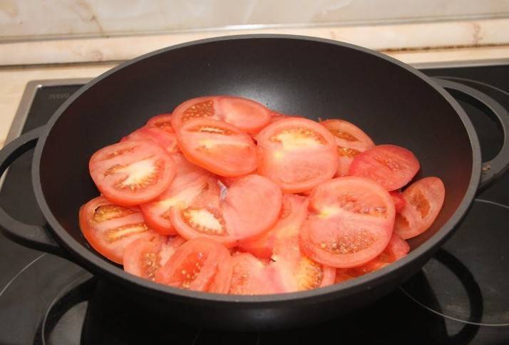 Помидоры промываем, нарезаем их кружочками и половину помидоров отправляем на мясо.