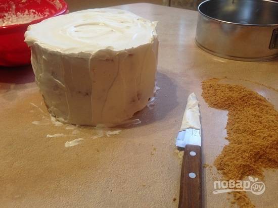 16. Освобождаем торт от пленки и смазываем со всех сторон оставленным кремом. Обрезки измельчаем скалкой в мелкую крошку и обсыпаем торт по бокам.