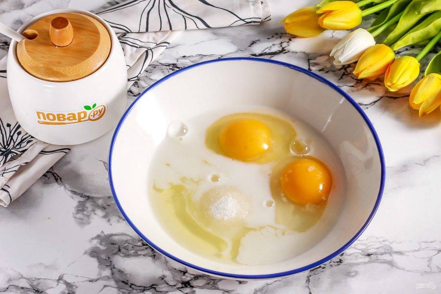Вбейте куриные яйца в глубокую емкость. Влейте молоко любой жирности, всыпьте сахар и соль. Взбейте все примерно 2-3 минуты.