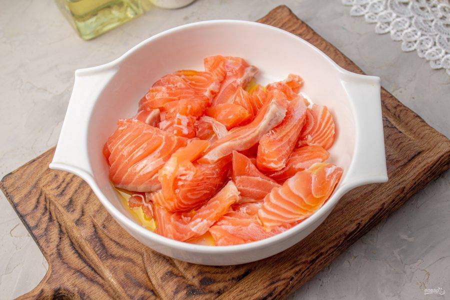 Переложите рыбу в подходящую посуду, смешайте с оливковым маслом и уберите в холодильник на 1 час. Посуду с рыбой накройте пищевой пленкой.