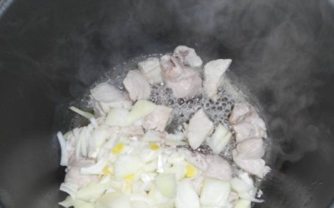 Нарезаем свинину кубиками. Вливаем в чашу мультиварки растительное масло, выставляем режим "Жарка" на 15 минут. Добавляем мясо, солим и перчим по вкусу. Через 15 минут добавьте измельченный лук.