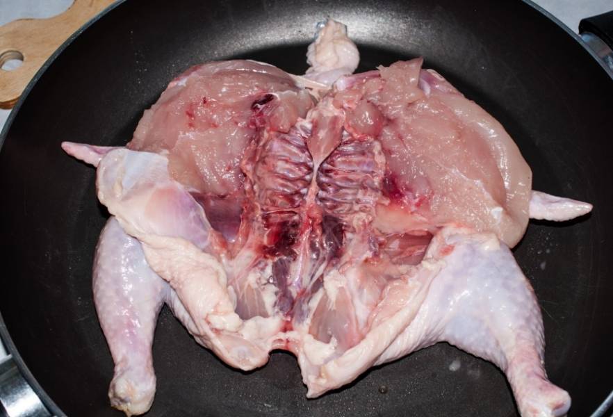 Разрезаем цыпленка по грудке, избавляемся от лишних косточек, перекладываем на сковородку.