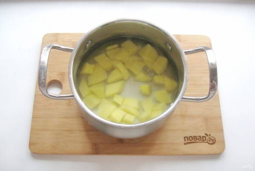 В кастрюлю налейте фильтрованную воду. Картофель очистите, помойте и нарежьте, выложите в кастрюлю. Поставьте на плиту и начинайте варить суп.