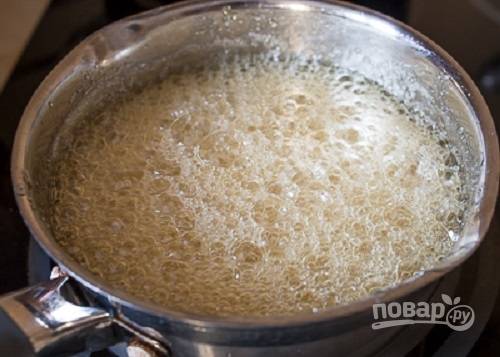Теперь будем варить нугу. Выкладываем в сотейник мед и 400 грамм сахара, добавляем воду и на среднем огне варим до температуры 135 градусов, то есть минут 10-12 после закипания. 