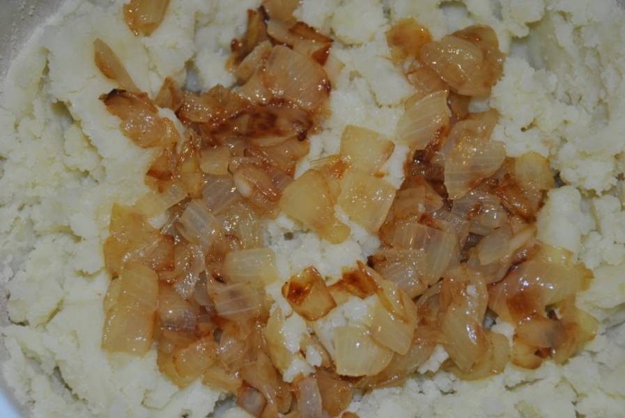 Картофель чистим и отвариваем до полной готовности, измельчаем его в пюре, добавляем обжаренный лук, молотый перец и соль, перемешиваем начинку.