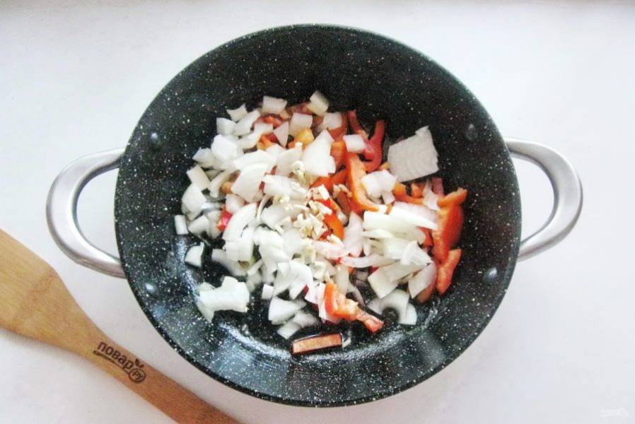 Выложите курицу на тарелку. Лук, чеснок и болгарский перец очистите и помойте. После нарежьте произвольно и выложите в сковороду, в которой вы жарили курицу. Обжаривайте эти овощи перемешивая в течение 7-8 минут.