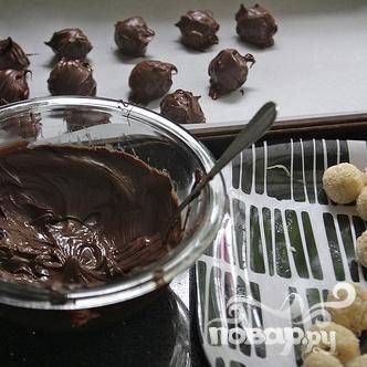 6. В микроволновой печи растопить шоколад примерно в течение 1-1 1/2 минут, пока он полностью не растает. Окунуть охлажденное кокосовые шарики в шоколадную смесь. Для этого удобно использовать две вилки. 
