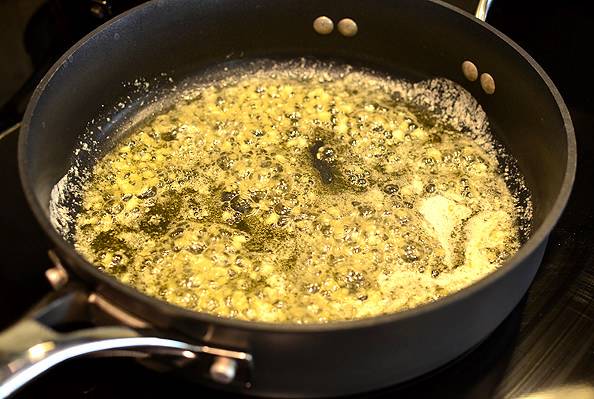 1. На сковороду отправить сливочное и оливковое масло. Как следует разогреть. Тем временем очистить и нарезать мелкими кубиками чеснок. Отправить его в масло и обжарить около 30 секунд. 