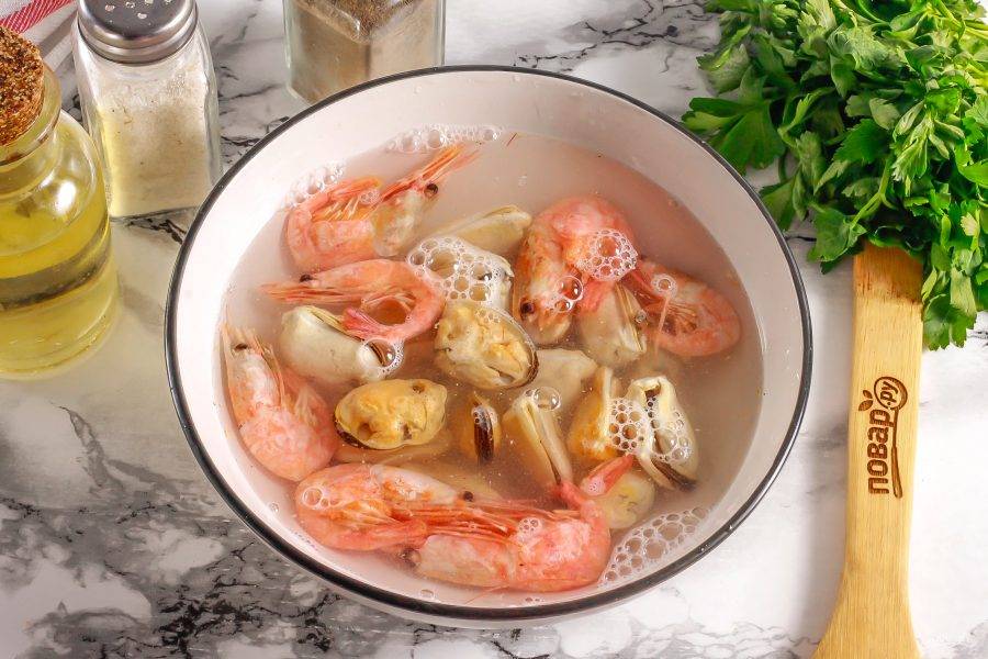 Морепродукты залейте теплой водой и разморозьте. Креветки очистите от панцирей.