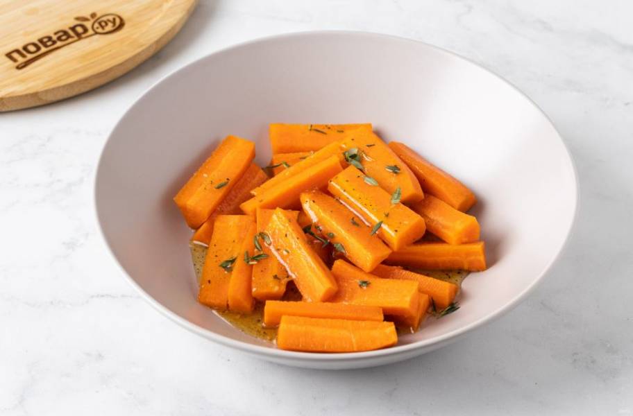 Полейте морковь медовым соусом. Добавьте листики тимьяна. Все перемешайте, чтобы соус равномерно распределился.