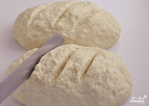 7. Придайте тесту желаемую форму. Белый хлеб в духовке в домашних условиях можно выпекать как на противне, так и в жаропрочной форме. 