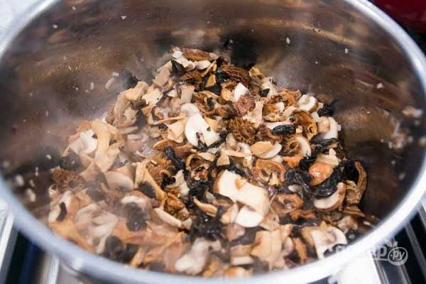На 3 ст. ложках масла в кастрюле обжариваем измельченный шалот до золотистости, затем добавляем нарезанные шампиньоны. Еще через 4 минуты - порезанные сушеные грибы.