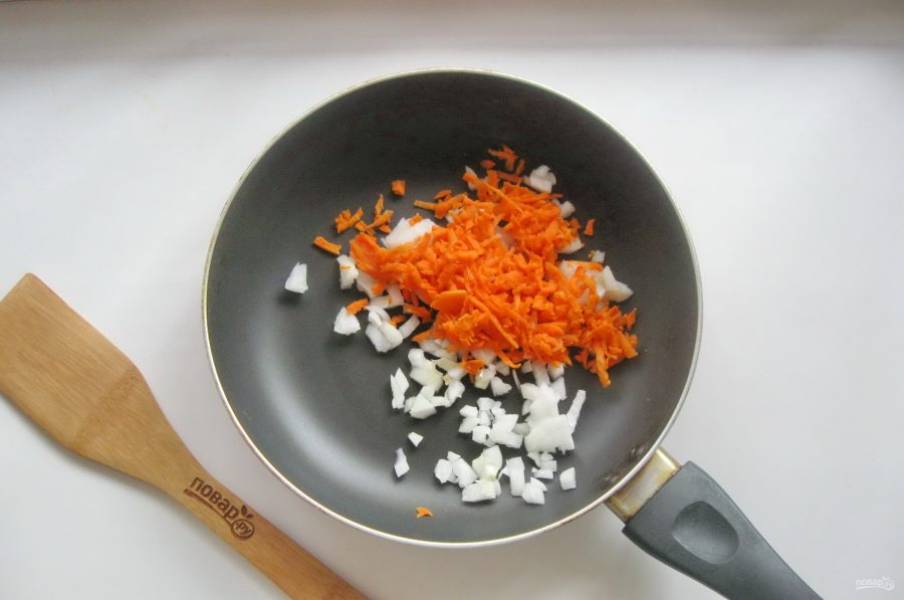 Морковь и лук очистите, помойте. Морковь натрите на терке, а лук мелко нарежьте. Выложите в сковороду.