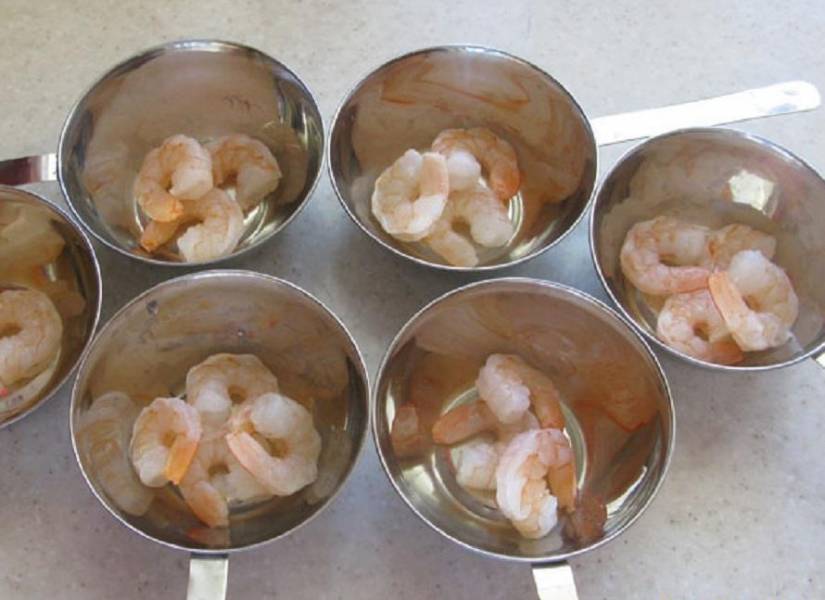 2. Варим креветки и на дно кокотницы выкладываем уже чищенные и не нарезанные морепродукты.