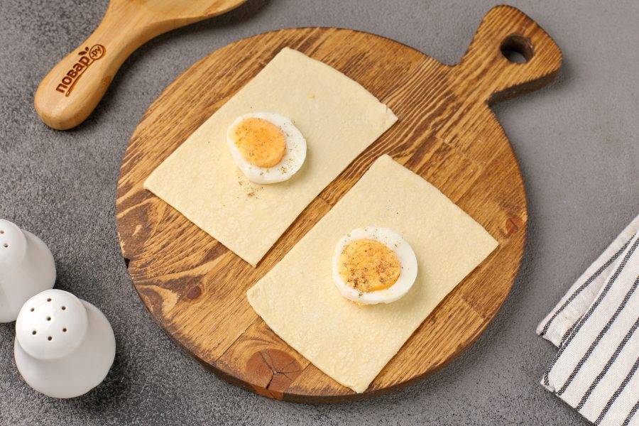 По центру выложите кружочек варёного яйца, посолите и поперчите по вкусу.