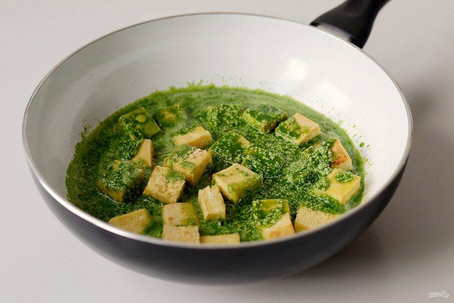 Добавьте в сковороду шпинатный соус и обжаренный тофу. Посолите, затем прогрейте все вместе пару минут.
