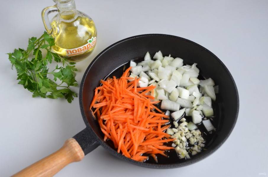 3. Измельчите овощи: лук порежьте кубиками, морковь натрите на крупной терке, чеснок пропустите через пресс или нарежьте кубиками. Обжарьте овощи до полуготовности на растительном масле.